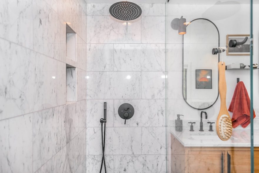 A tiled walk-in shower in a renovated bathroom