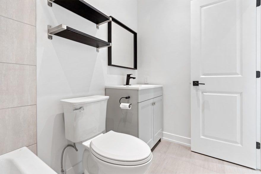 A clean modern bathroom with a toilet and vanity